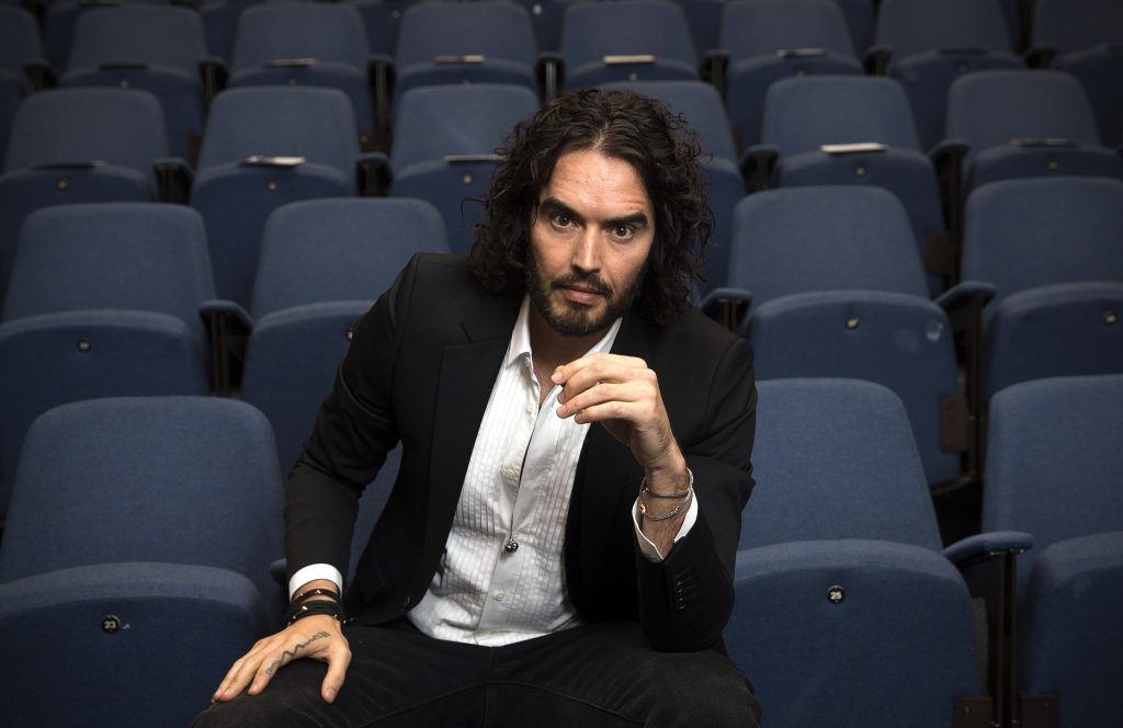 Russell Brand poses for photographs as he arrives to deliver The Reading Agency Lecture at The Institute of Education on November 25, 2014 in London, England. 