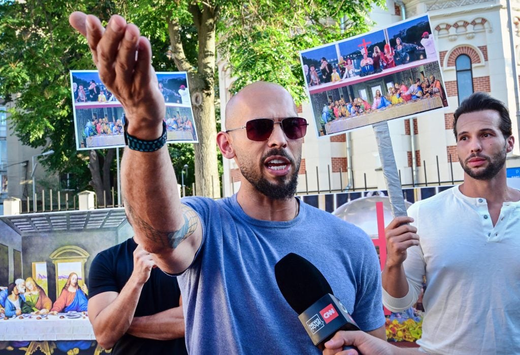 Andrew Tate and his brother Tristan Tate speak during a protest against the Olympics next to the French Embassy to Romania in Bucharest, on July 28, 2004.