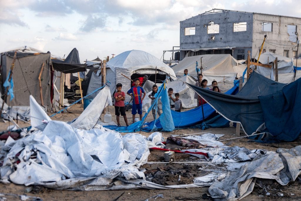 Children look over the aftermath of yet another bombing by the IDF.