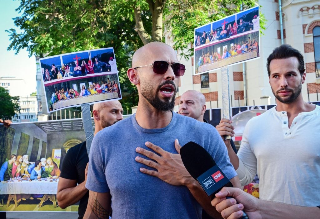 Andrew Tate and his brother Tristan Tate speak during a protest against the Olympics next to the French Embassy to Romania in Bucharest, on July 28, 2004.