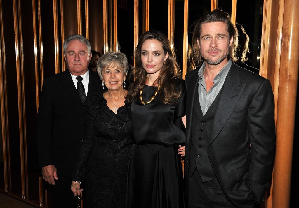 Angelina Jolie and Brad Pitt pose with Bill Pitt and Jane Pitt at the after party for the premiere of In the Land of Blood and Honey at the The Standard Hotel Rooftop on December 5, 2011 in New York City. 