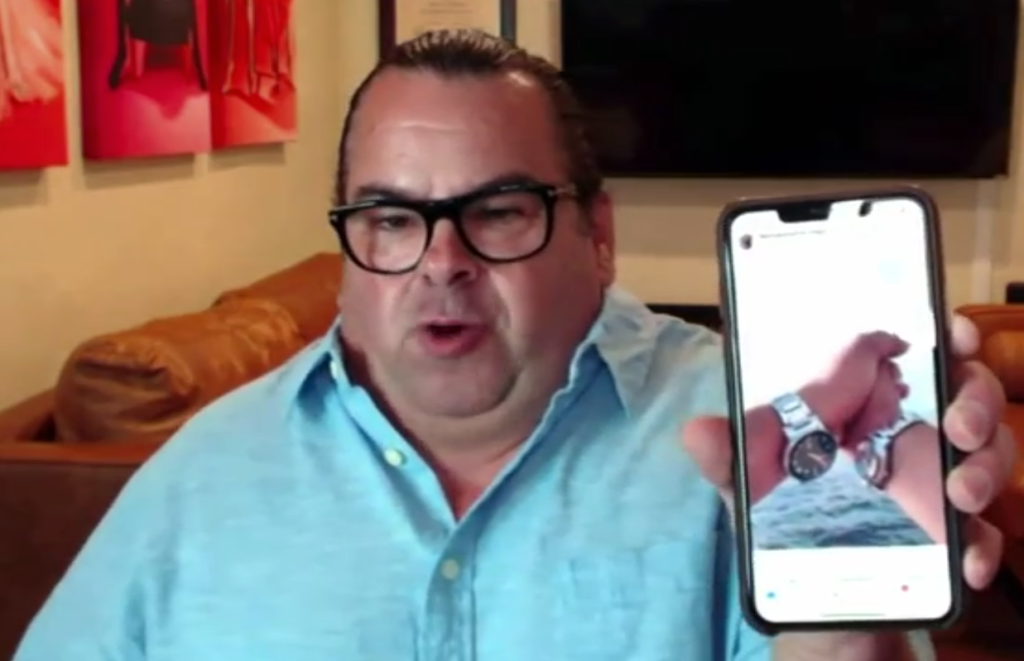 Big Ed Brown sweats and holds up a phone indignantly.