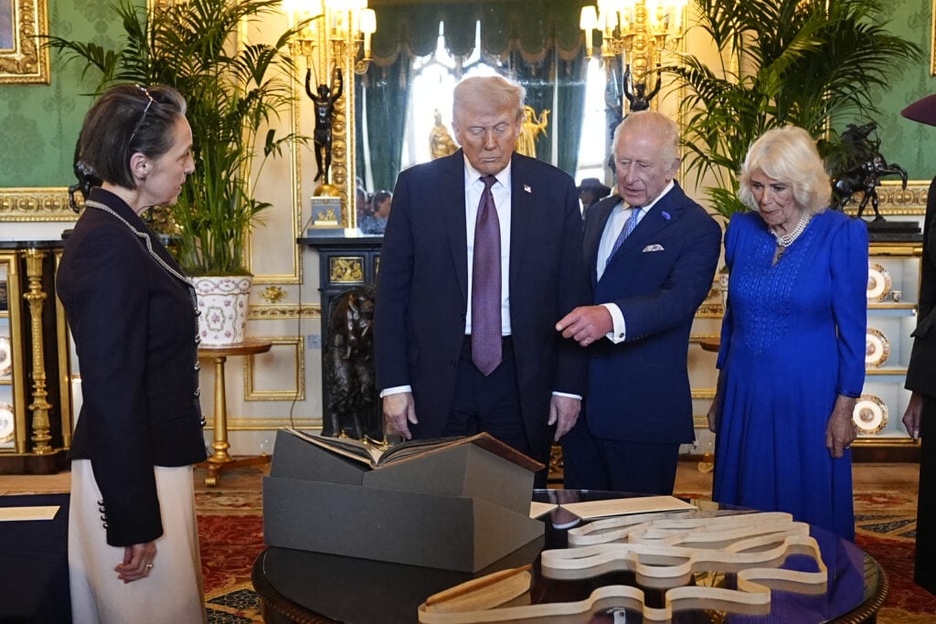 US President Donald Trump, King Charles III and Queen Camilla view items on display during a visit to the Royal Collection exhibition, in the Green Drawing Room during the State visit by the President of the United States of America at Windsor Castle on September 17, 2025 in Windsor, England. 