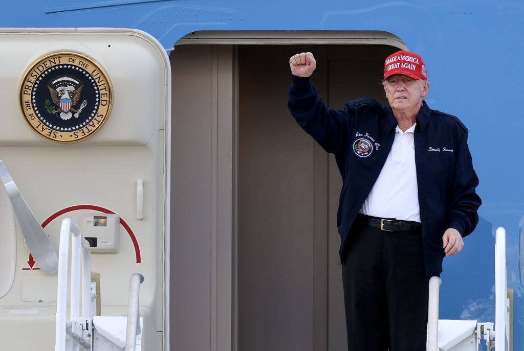 U.S. President Donald Trump gestures as he departs Air Force One at Miami International Airport on February 19, 2025 in Miami, Florida.