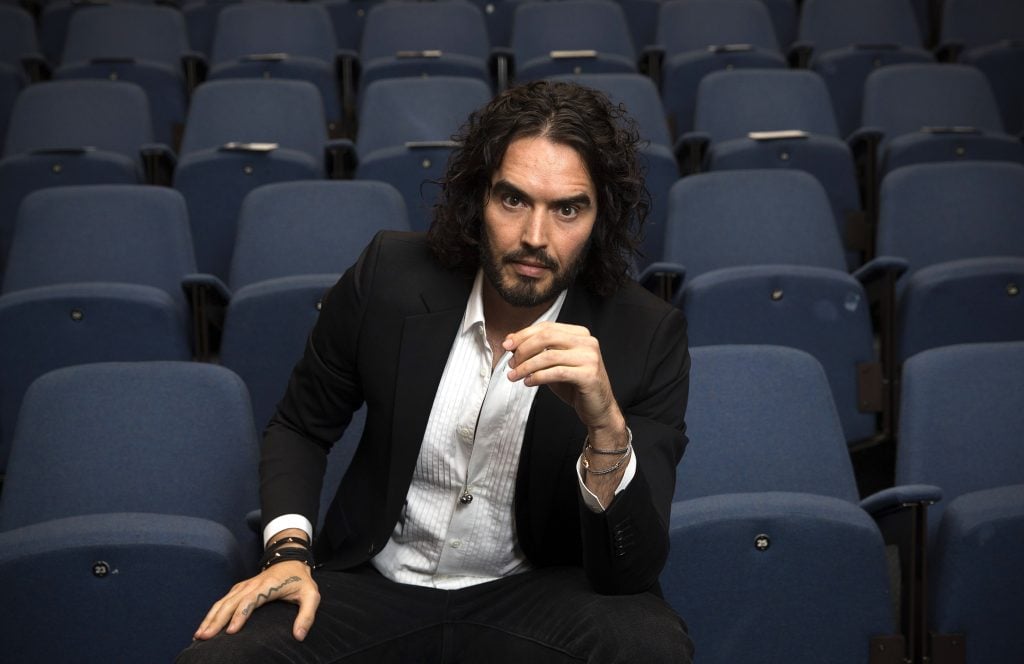 Russell Brand poses for photographs as he arrives to deliver The Reading Agency Lecture at The Institute of Education on November 25, 2014 in London, England. 