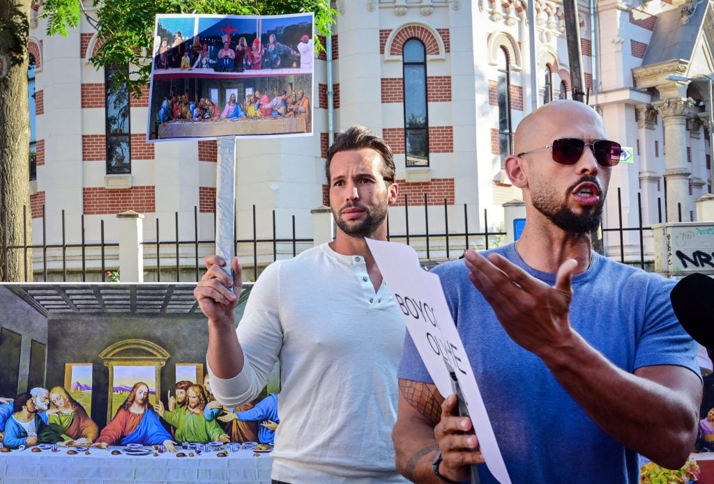 Andrew Tate and his brother Tristan Tate old pancards during a protest against the Olympics next to the French Embassy to Romania in Bucharest, on July 28, 2004. The Tate brothers criticized the Paris 2024 Olympic Games for the inclusion message offered during the opening ceremony.