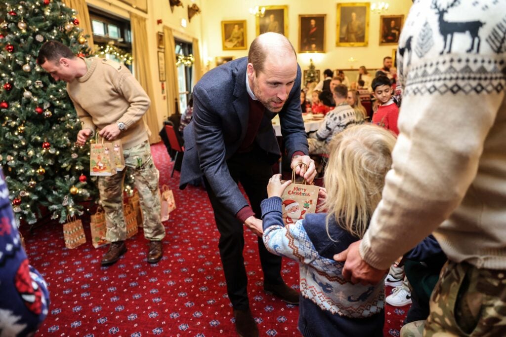 Prince William, Prince of Wales, Colonel-in-Chief, 1st Battalion Mercian Regiment, hands out small presents to the children of serving soldiers during a visit to the Regiment for a Christmas event for families at Picton Barracks on December 10, 2024 in Bulford, Wiltshire.