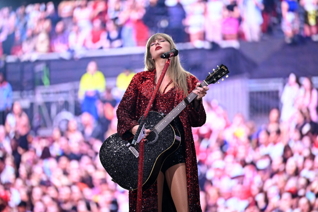 Taylor Swift strums the guitar