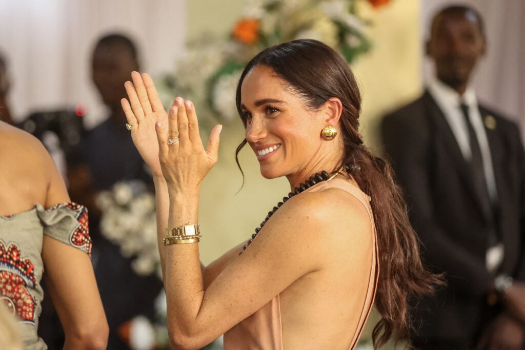 Meghan, Duchess of Sussex, gestures as she arrives with Britain's Prince Harry (unseen), Duke of Sussex, during their visit at the Lightway Academy in Abuja on May 10, 2024 as they visit Nigeria as part of celebrations of Invictus Games anniversary. 