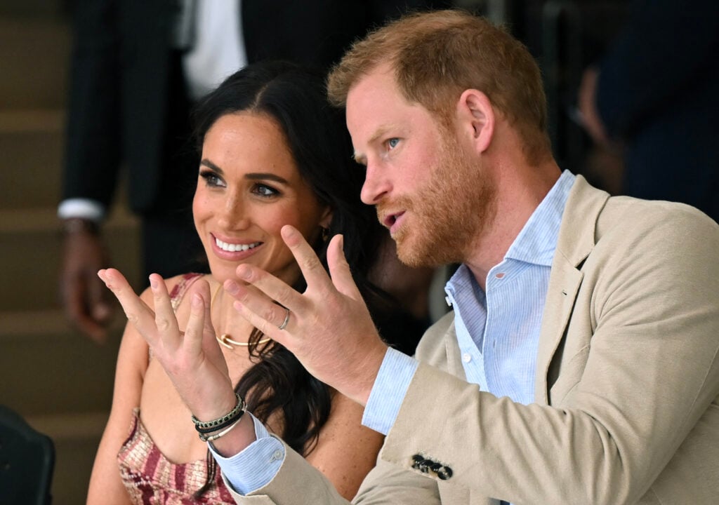 Prince Harry, Duke of Sussex, speaks with his wife Meghan Markle while attending a show during a visit to the National Centre for the Arts in Bogota on August 15, 2024. 